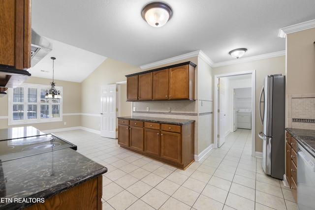 kitchen with decorative light fixtures, stainless steel appliances, backsplash, brown cabinets, and washer / dryer