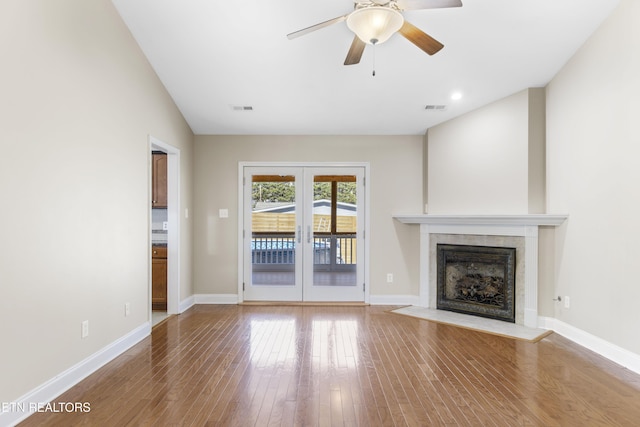 unfurnished living room with baseboards, visible vents, and wood finished floors