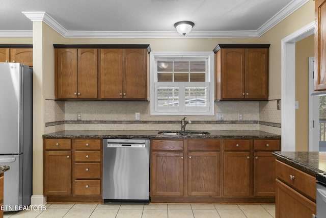 kitchen with stainless steel appliances, backsplash, ornamental molding, a sink, and dark stone countertops