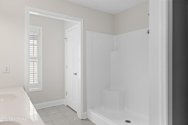 full bathroom with a shower stall, vanity, baseboards, and tile patterned floors