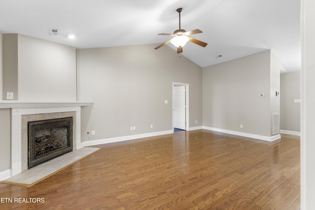 unfurnished living room with baseboards, visible vents, wood finished floors, and a tile fireplace