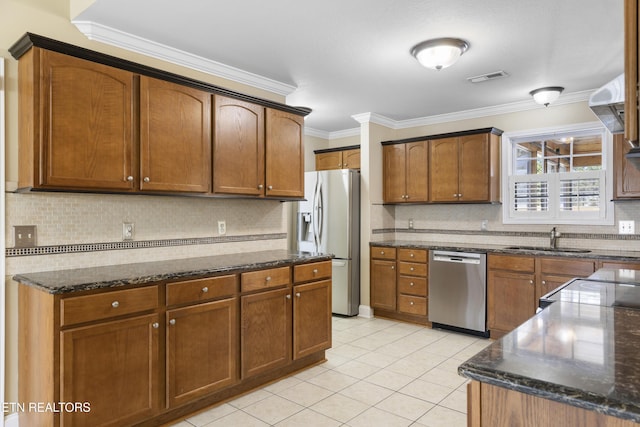 kitchen featuring light tile patterned floors, appliances with stainless steel finishes, brown cabinets, crown molding, and a sink