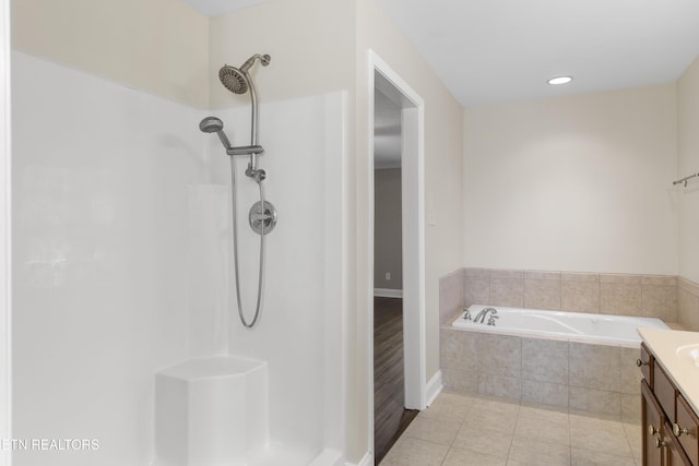 bathroom with a shower, tile patterned floors, vanity, and a bath