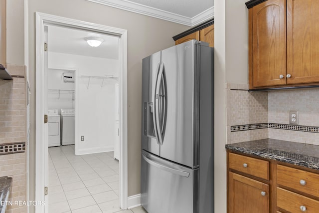 kitchen featuring crown molding, light tile patterned floors, stainless steel fridge, and brown cabinets