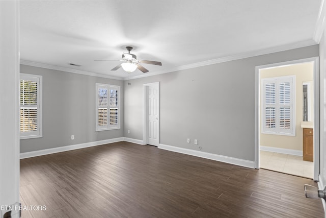 spare room with visible vents, baseboards, dark wood-style floors, ceiling fan, and crown molding