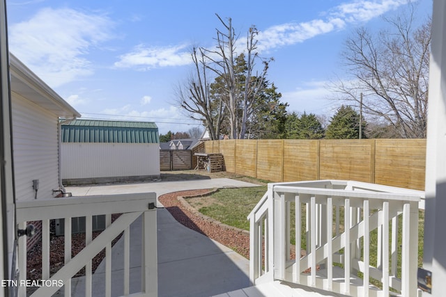 view of yard featuring a storage shed, a fenced backyard, a patio, and an outdoor structure