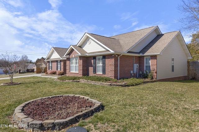 view of front of house featuring brick siding, a front yard, and a shingled roof