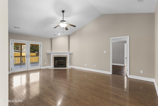 unfurnished living room featuring lofted ceiling, a tile fireplace, a ceiling fan, baseboards, and dark wood-style floors