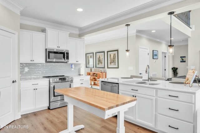 kitchen featuring light countertops, decorative backsplash, appliances with stainless steel finishes, white cabinets, and a sink