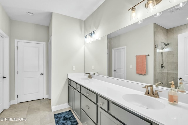 full bathroom with tile patterned flooring, a sink, baseboards, a shower stall, and double vanity