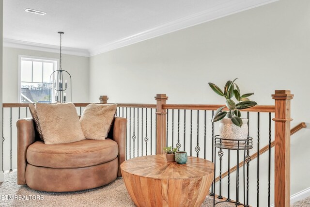 living area featuring an inviting chandelier, visible vents, an upstairs landing, and ornamental molding