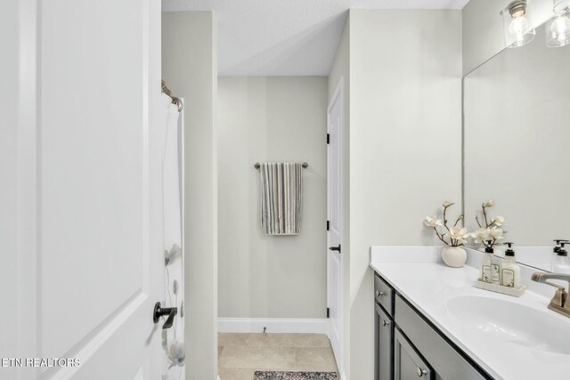 full bathroom with baseboards, vanity, and tile patterned floors