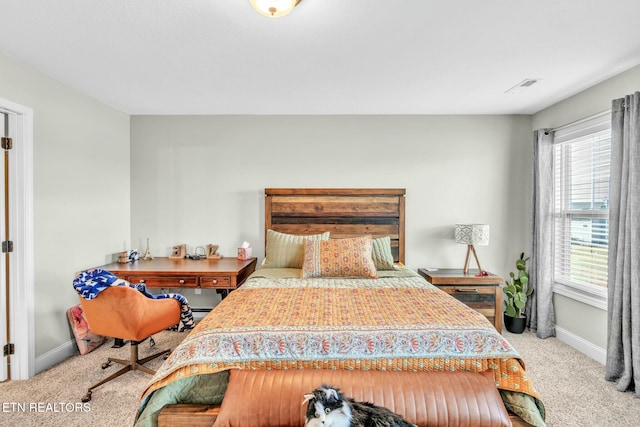 bedroom with carpet floors, visible vents, and baseboards