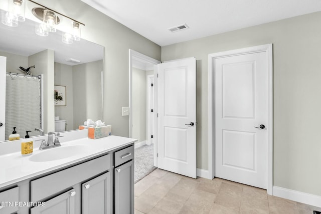 full bath with curtained shower, toilet, visible vents, vanity, and baseboards