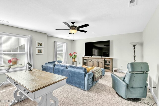 living room featuring baseboards, carpet flooring, visible vents, and a ceiling fan