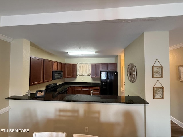 kitchen featuring a peninsula, black appliances, baseboards, and dark stone countertops