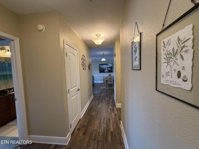 hallway with dark wood-style flooring and baseboards