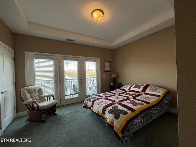 carpeted bedroom with access to exterior, visible vents, and a tray ceiling