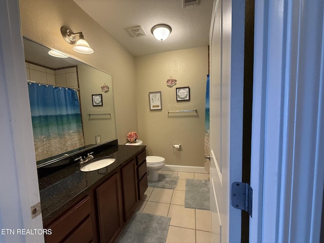 bathroom with visible vents, toilet, tile patterned floors, a textured ceiling, and vanity