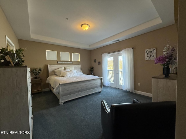 bedroom with a tray ceiling, french doors, dark colored carpet, visible vents, and access to outside