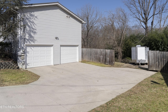 exterior space featuring fence, a garage, and driveway