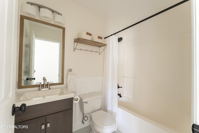 full bathroom featuring vanity, a wainscoted wall, toilet, and shower / bath combo with shower curtain