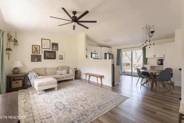 living room with a textured ceiling, dark wood-style floors, a ceiling fan, and vaulted ceiling