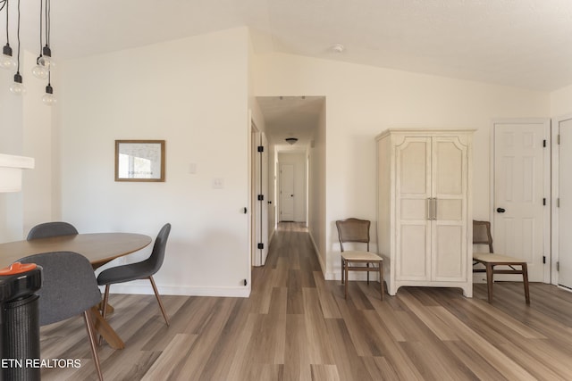 office area with baseboards, lofted ceiling, and wood finished floors