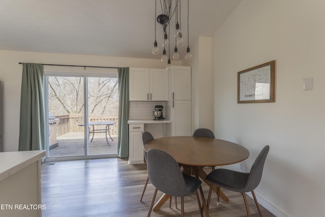 dining space featuring baseboards and wood finished floors