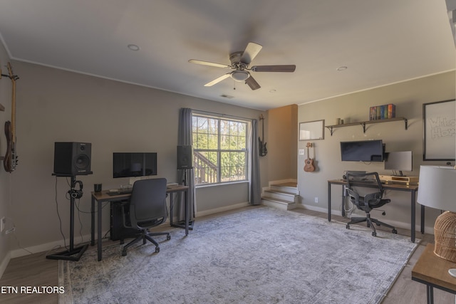 office space featuring baseboards, wood finished floors, and a ceiling fan