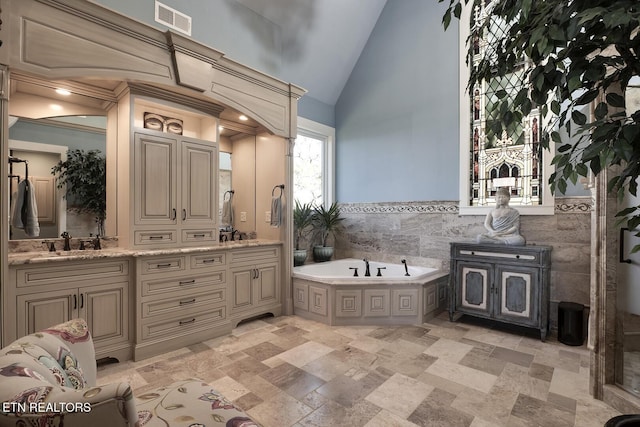 245 Harrison Bend Rd, Loudon, TN 37774 - bathroom with visible vents, double vanity, a sink, vaulted ceiling, and a garden tub
