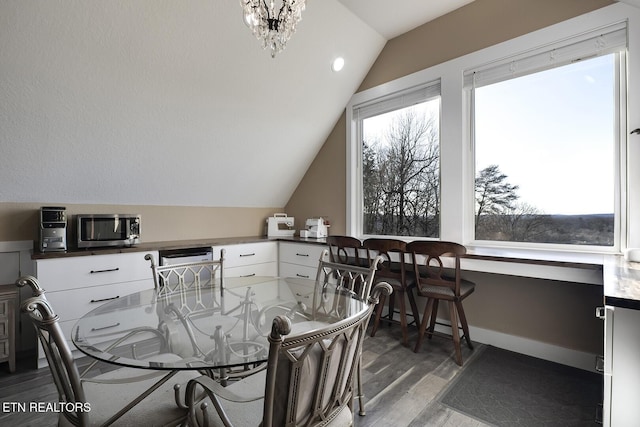 245 Harrison Bend Rd, Loudon, TN 37774 - dining room with an inviting chandelier, vaulted ceiling, wood finished floors, and baseboards