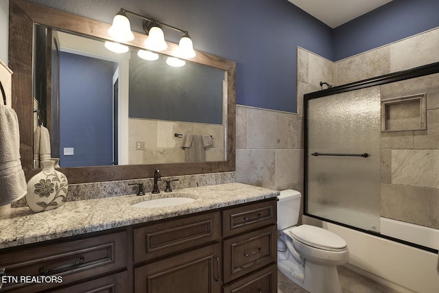 245 Harrison Bend Rd, Loudon, TN 37774 - bathroom with vanity, tile walls, toilet, and bath / shower combo with glass door