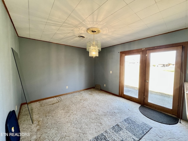 spare room with french doors, visible vents, an inviting chandelier, carpet flooring, and baseboards