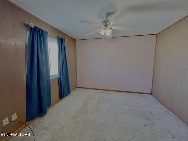 carpeted empty room with a ceiling fan