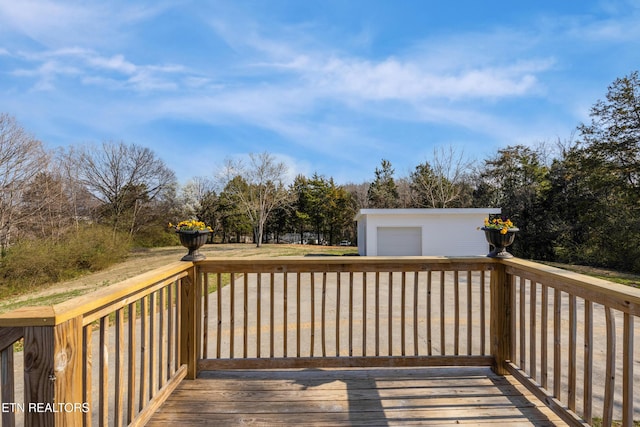 wooden deck featuring an outdoor structure and a garage