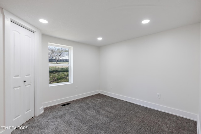 unfurnished bedroom featuring dark colored carpet, visible vents, baseboards, and recessed lighting