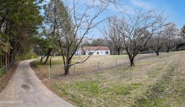 view of yard with fence and driveway