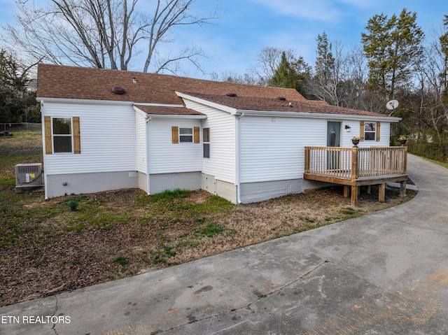 back of property with central air condition unit, a wooden deck, roof with shingles, crawl space, and driveway