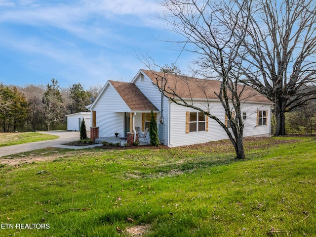 view of front of house featuring a porch, driveway, and a front lawn