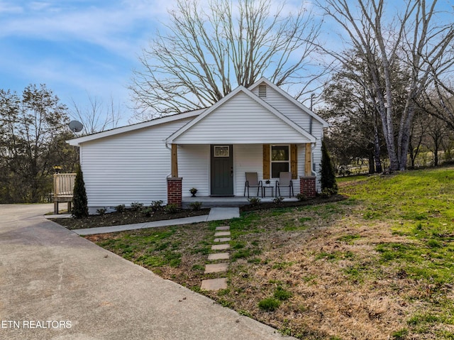 bungalow featuring a porch and driveway