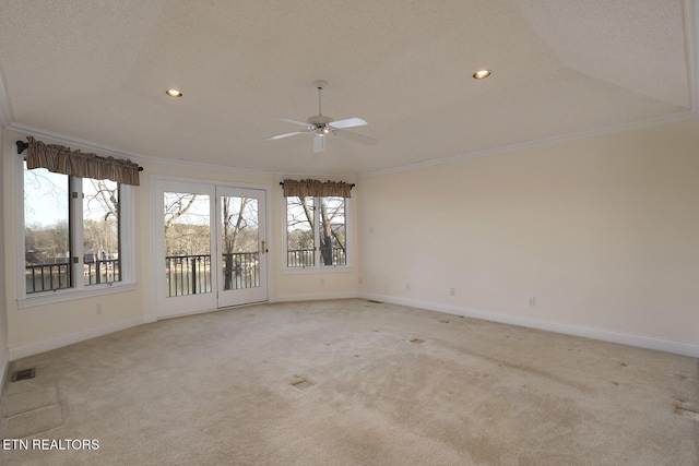 empty room featuring visible vents, ornamental molding, baseboards, and light colored carpet