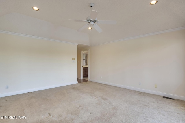 empty room with visible vents, baseboards, light colored carpet, ceiling fan, and vaulted ceiling