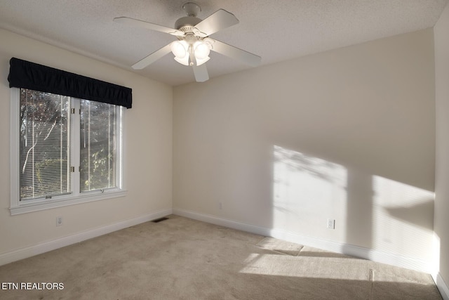 unfurnished room with visible vents, light carpet, a textured ceiling, and baseboards