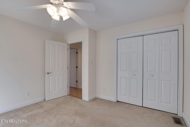 unfurnished bedroom featuring light carpet, baseboards, visible vents, a ceiling fan, and a closet