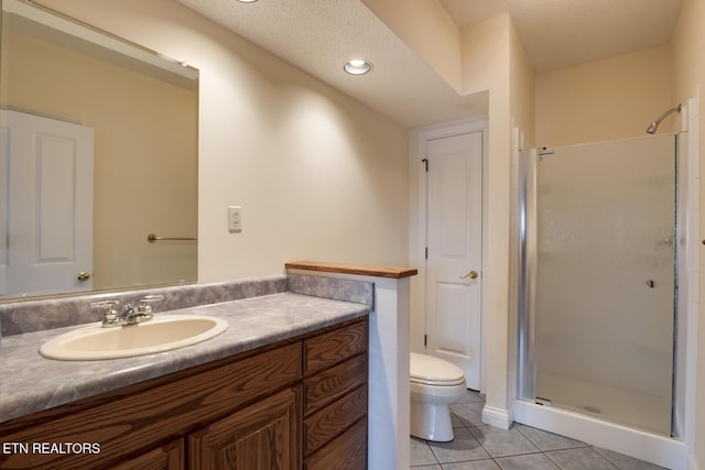 full bathroom with vanity, tile patterned flooring, toilet, and a shower stall