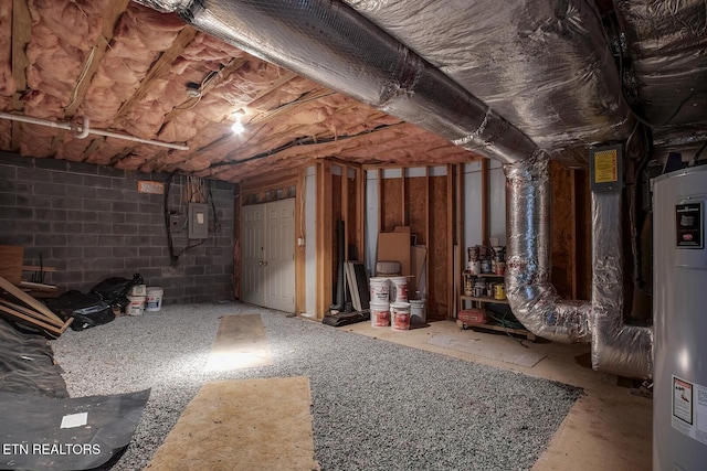 unfinished below grade area featuring concrete block wall, electric panel, and electric water heater