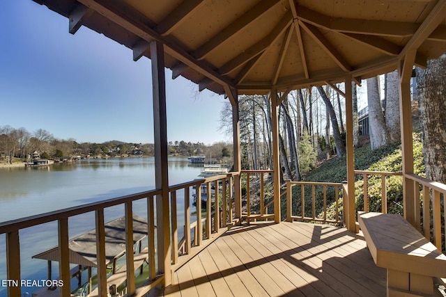 wooden terrace featuring a water view and a gazebo