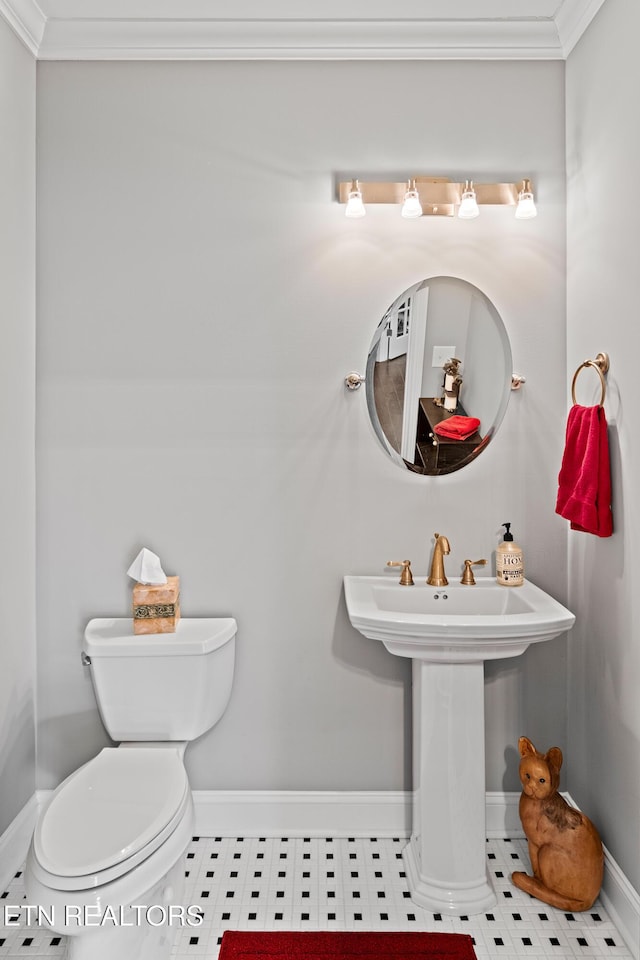 half bath with toilet, baseboards, and crown molding