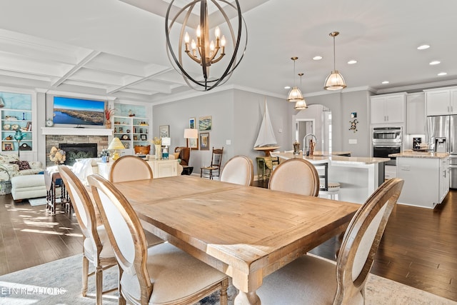 dining room with arched walkways, recessed lighting, dark wood-style flooring, coffered ceiling, and a fireplace